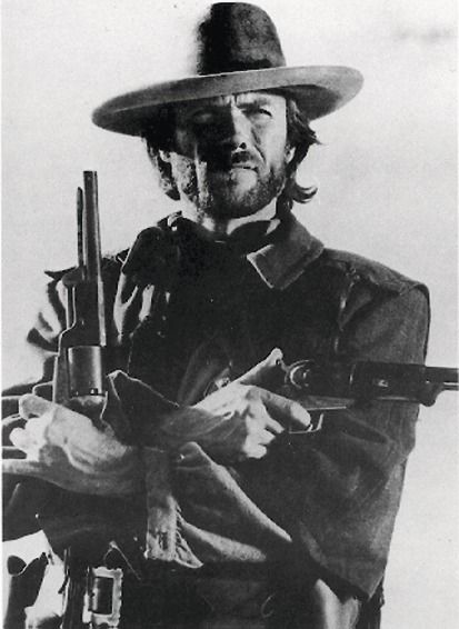 Clint Eastwood w kapeluszu kowbojskim z dwoma rewolwerami
