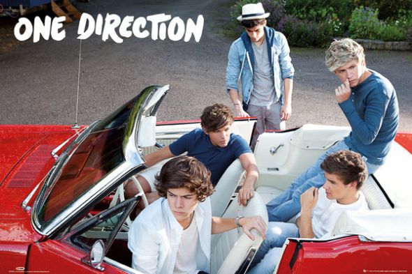 Członkowie zespołu One Direction siedzący w czerwonym samochodzie