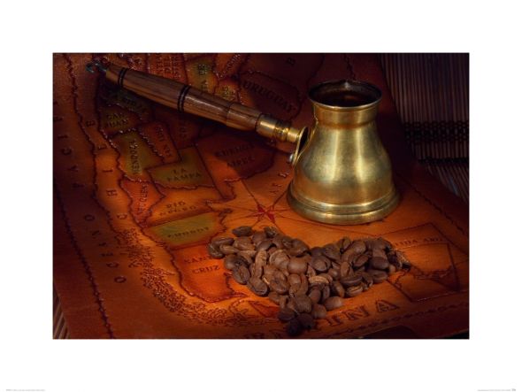 reprodukcja przedstawiająca starą mapę na której leżą ziarna kawy i młynek
