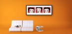aranżacja obrazu w czarnej ramie z Betty Boop na pomarańczowej ścianie w pokoju nad białą sofą