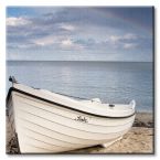 canvas na ścianę przedstawiający białą łódź zacumowaną na piaszczystej plaży na tle spokojnego morza i zachmurzonego nieba