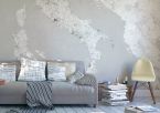 Duża mapa Włoch wisząca na ścianie w salonie nad szarą kanapą
