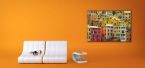 kolorowy obraz z włoskimi domami w pomarańczowym pokoju nad białą sofą