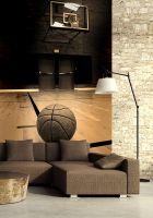 aranżacja fototapety przedstawiająca piłkę do gry w koszykówkę leżącą na parkiecie hali sportowej a w tle nad czarnymi drzwiami widać obręcz kosza idealna do powieszenia w salonie z szarymi ścianami i dwoma dużymi sofami