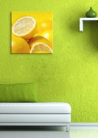 aranżacja obrazu z żółtymi cytrynami w zielonym pokoju nad białą sofą
