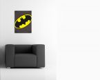 aranżacja obrazu z czarno-żółtym symbolem Batmana w białym pokoju nad czarnym fotelem