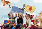 Dzieci bawiące się w przedszkolu a w tle bajkowa fototapeta Disneya z Kubusiem Puchatkiem