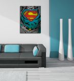 aranżacja wnętrza z obrazem przedstawiającym tors z symbolem Supermana w salonie z białymi i turkusowymi ścianami wiszący nad czarną sofą