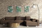 Obrazy na płótnie wiszące w salonie nad brązową kanapą przedstawiające zielone liście
