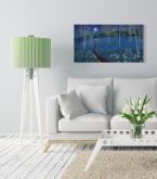 Canvas Blue Moon wiszący w jasnym salonie nad białą kanapą