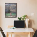 Zdjęcie w drewnianej ramie wiszące nad komputerem w pokoju