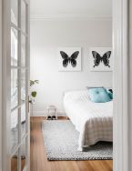 Obrazy na płótnie wiszące na białej ścianie nad łóżkiem