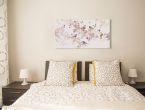 Canvas o nazwie Birds and Blossom autorstwa Summer Thornton powieszony w sypialni nad łóżkiem