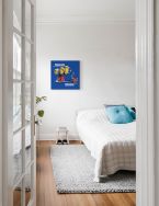 Obraz przedstawiający minionki na niebieskim tle powieszony na ścianie w sypialni
