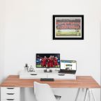 Obraz w czarnej ramce powieszony na białej nad biurkiem ścianie z zawodnikami Liverpoola