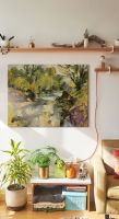 Canvas przedstawiający piękny malowniczy krajobraz wiszący nad ławą z kwiatami doniczkowymi