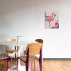 Canvas przedstawiający różowego flaminga na biały tle powieszony na ścianie w jadalni