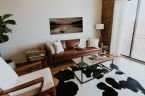 Obraz przedstawiający jezioro z kamieniami wiszący w stylowym salonie nad brązową skórzaną kanapą