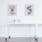 Kwiecisty canvas powieszony nad białym stolikiem w pokoju