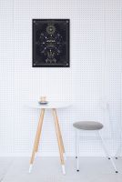 Obraz na płótnie autorki Cat Coquillette powieszony na ścianie w kropki nad stolikiem