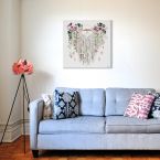 Kwiecisty Canvas w rozmiarze 60x60 cm powieszony nad błękitną kanapą w salonie