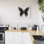 Canvas przedstawiający czarnego motyla na białym tle wiszący w kuchni nad blatem
