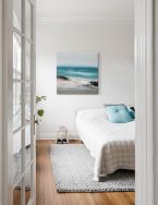 Ściana w sypialni udekorowana obrazem na płótnie przedstawiającym morski krajobraz