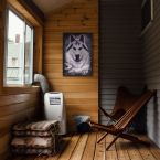 Obraz na drewnie z niebieskookim wilkiem powieszony na ścianie