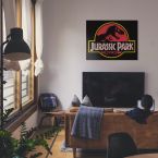 Canvas z logo Jurassic Park powieszony w salonie nad telewizorem