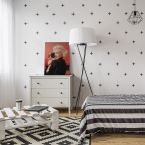 Aranżacja nowoczesnej dziewczęcej sypialni z postawionym na komodzie obrazem na płótnie z Marylin Monroe