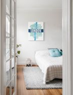Canvas z niebieskim napisem London powieszony w sypialni nad łóżkiem