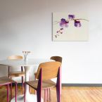 Canvas z fioletową orchideą powieszony na białej ścianie