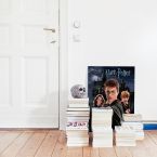 Obraz na płótnie przedstawiający Harrego, Hermionę i Rona postawiony na podłodze wśród książek