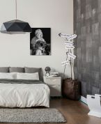 Czarno-biały obraz na którym przedstawiona jest Marylin Monroe z lutnią powieszony w sypialni nad łóżkiem