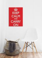 Obraz zatytułowany Keep Calm and Carry On powieszony nad białym krzesłem i koszem wiklinowym