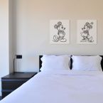 Obraz na płótnie o nazwie Myszka Mickey Rysunek powieszony w sypialni nad łóżkiem obok obrazka z Myszką Minnie