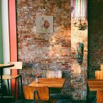 Obraz na płótnie Dwie kury powieszony w barze na ceglanej ścianie nad stolikiem z sokiem pomidorowym