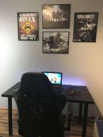 Poster z gry Call of Duty Ghost oprawiony w czarną ramę i powieszony nad biurkiem