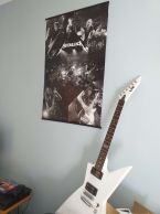 Poster z zespołem metallica powieszony obok gitary elektrycznej