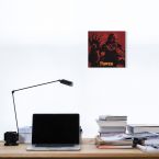 Czerwony obraz z gry The Legend Of Zelda Power powieszony nad biurkiem z laptopem, książkami i czarną lampką