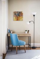 Jesienny obraz z brzozowym lasem zawieszony w pokoju nad biurkiem i niebieskim krzesłem
