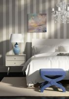 Kolorowy obraz z chmurami powieszony w sypialni na ścianie w pasy nad łóżkiem i szafką z lampką