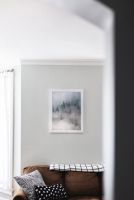 Zamglony las na plakacie w białej ramie powieszonym w salonie nad kanapą