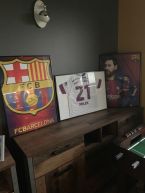 Sportowy plakat Barcelona Leo Messi 17/18 w czarnej ramie postawiony na komodzie
