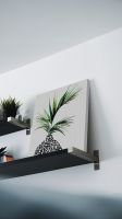 Obraz botaniczny Areca Palm Plant postawiony na czarnej półce