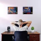Obrazy na płótnie wiszące na ścianie nad monitorem w pokoju gracza
