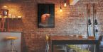 Plakat z muffinką powieszony w kawiarni na ścianie z cegły