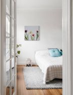 Obraz na płótnie z kolorowymi tulipanami powieszony w sypialni na białej ścianie