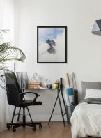 Plakat przedstawiający erupcję wulkanu powieszony nad biurkiem w sypialni
