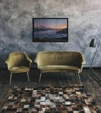 Plakat Alpejska Kraina w czarnej ramie nad kanapą w salonie